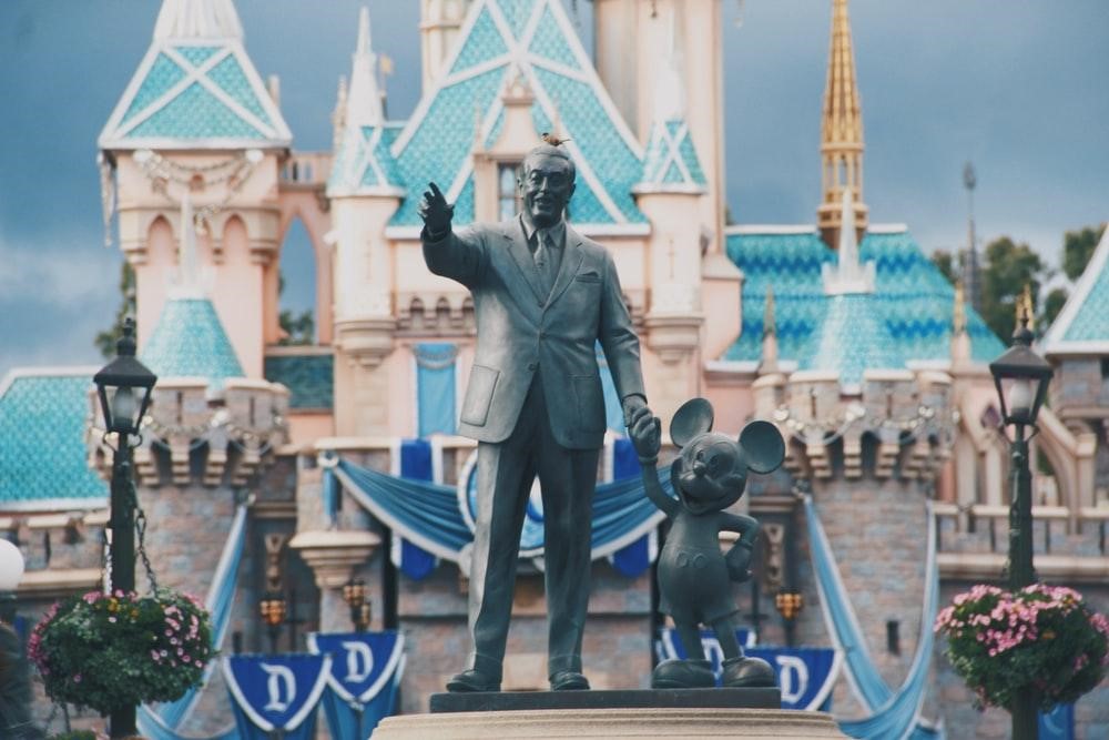 Walt Disney and mickey mouse in front of Disney world