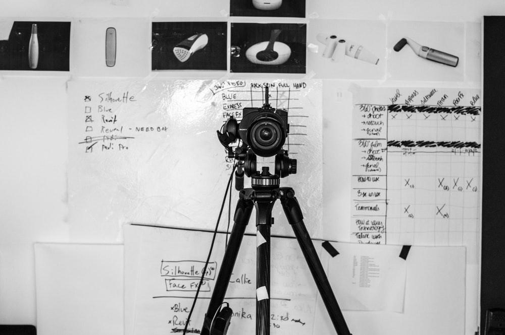 camera on a tripod infront of whiteboard