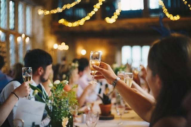 people raising glasses for toast at wedding