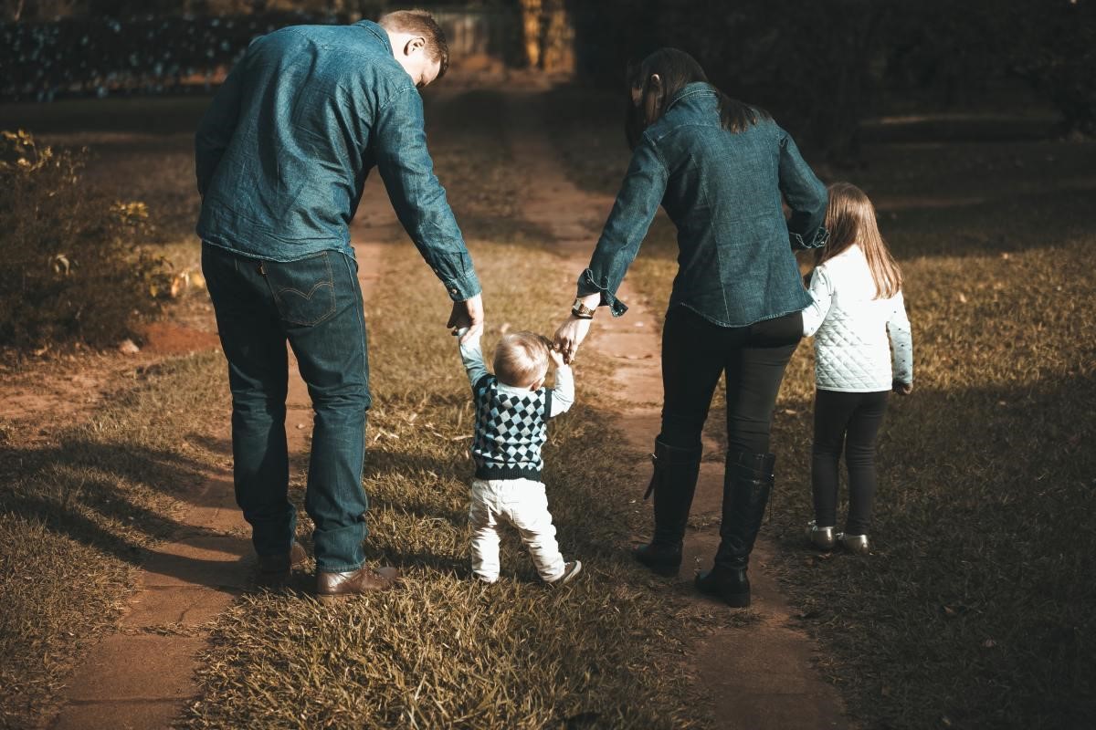 couple walking in the park with their two kids