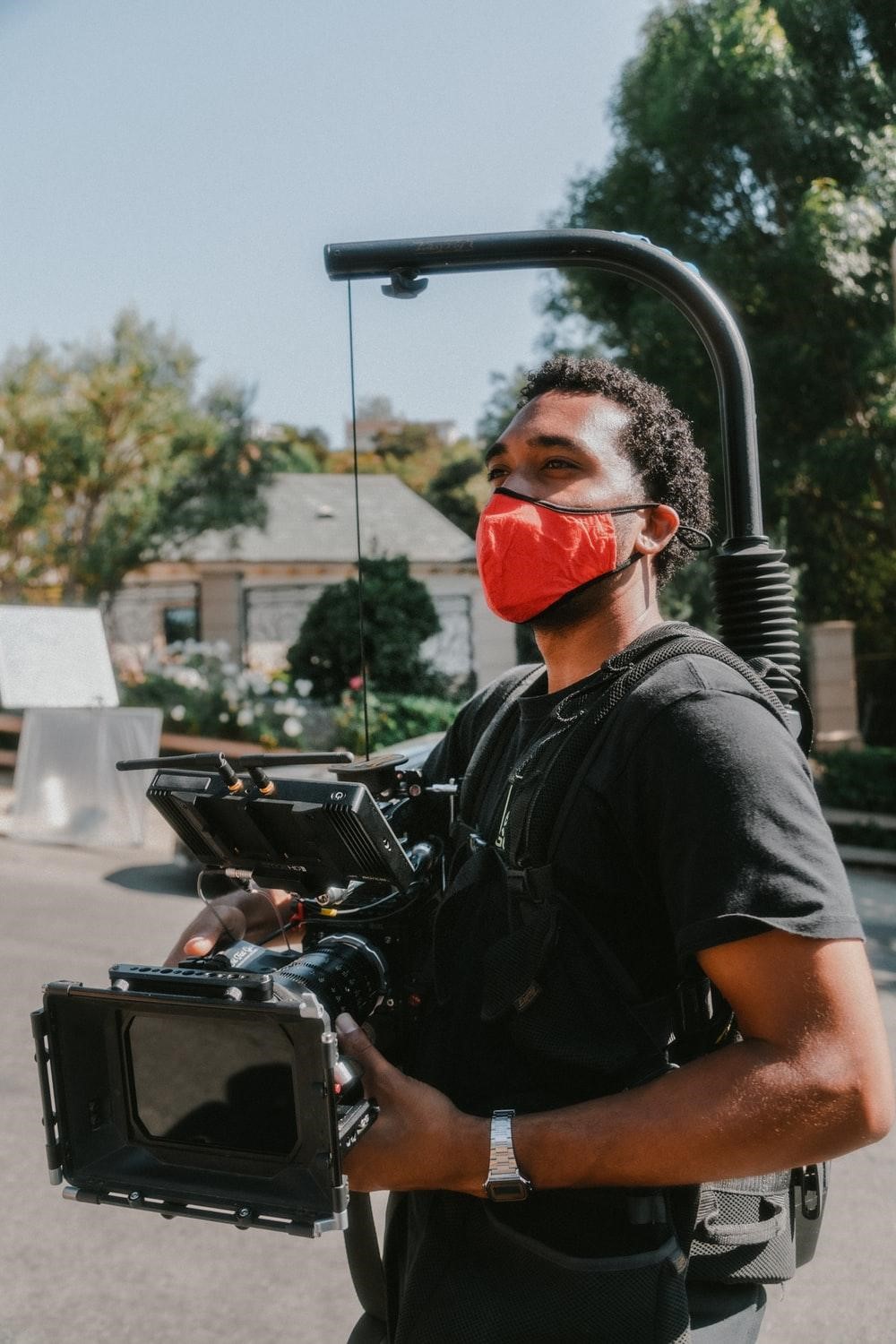 a professional videographer holding a camera with attachments