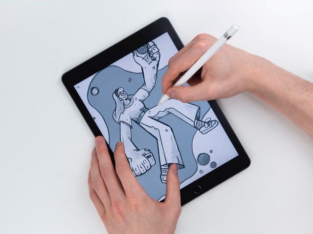 illustrator creating cartoon art on digital tab